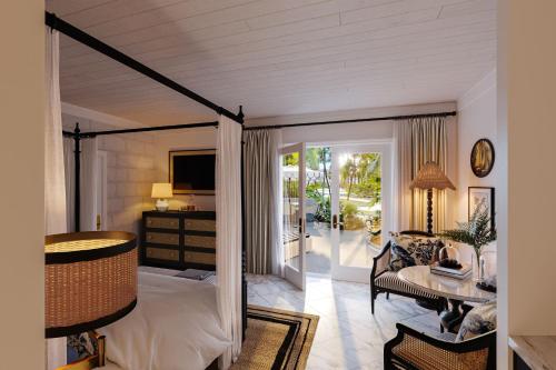 a bedroom with a bed and a desk and a television at Colony Club, a Luxury Collection Resort, Barbados in Saint James