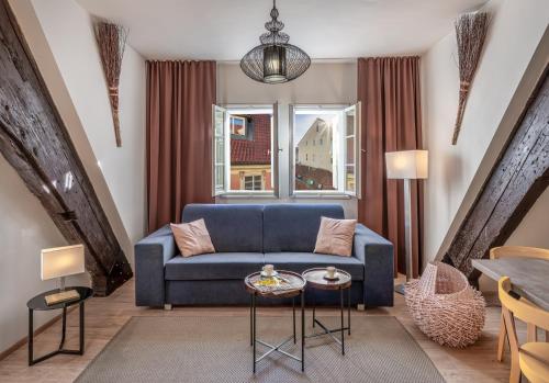 ein Wohnzimmer mit einem blauen Sofa und einem Tisch in der Unterkunft 7 Tales Apartments by Adrez in Prag