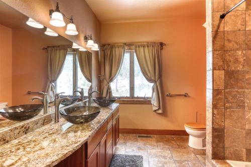 a bathroom with three sinks and a shower at Westwinds Lodge in Lead