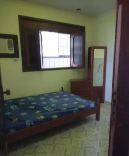 1 dormitorio con cama y ventana en Carneiros Camping Hostel, en Tamandaré