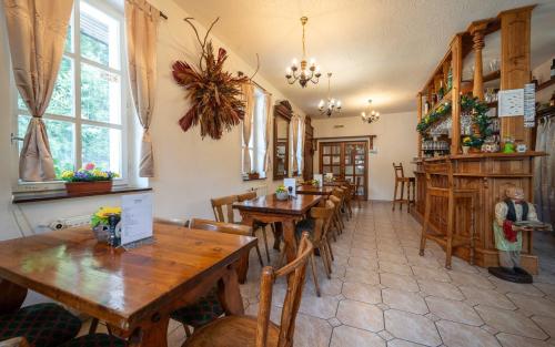 un restaurante con mesas de madera y sillas en una habitación en Hotýlek na Mýtě en Harrachov