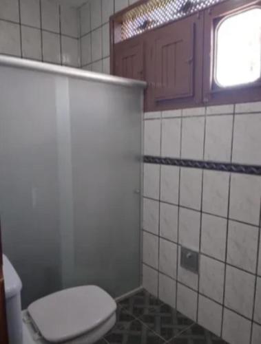 a bathroom with a toilet and a window at Carneiros Camping Hostel in Tamandaré