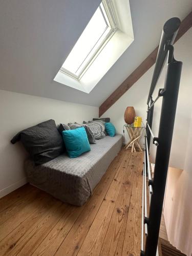a living room with a couch and a skylight at La Clé de Taulé in Taulé