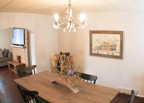 a dining room with a wooden table and a chandelier at Massive 4 Bed House-Short Walk to Amazing View in Pittsburgh