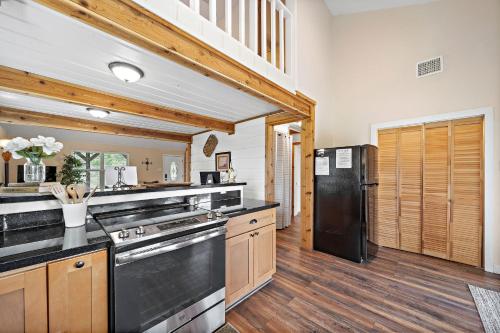 a kitchen with wooden floors and a black refrigerator at Old and Lost River Home on the river by Super Hosts instant book barbers hill wifi work space fishing hunting bird watching in Baytown