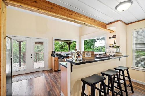 a kitchen with a bar with stools in it at Old and Lost River Home on the river by Super Hosts instant book barbers hill wifi work space fishing hunting bird watching in Baytown