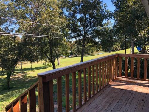 a wooden deck with a view of a park at Old and Lost River Home on the river by Super Hosts instant book barbers hill wifi work space fishing hunting bird watching in Baytown