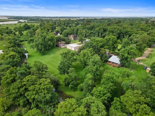 an overhead view of a house in a field with trees at Old and Lost River Home on the river by Super Hosts instant book barbers hill wifi work space fishing hunting bird watching in Baytown