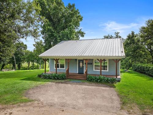 a small white house with a tin roof at Old and Lost River Home on the river by Super Hosts instant book barbers hill wifi work space fishing hunting bird watching in Baytown