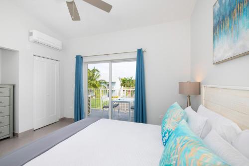 a bedroom with a bed and a sliding glass door at Summertime Suites #49 in West Bay