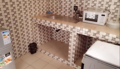 a kitchen with a sink and a microwave on a counter at Salam in Thiès