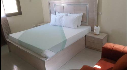 1 dormitorio con 1 cama blanca grande y ventana en Salam, en Thiès