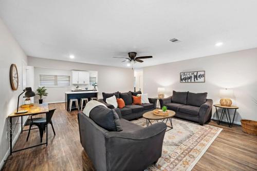 a living room with a couch and a table at Pool 5 Star Large Deer Park home Super Host in Deer Park