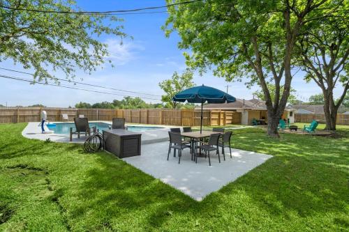 een terras met een tafel, stoelen en een parasol bij Pool 5 Star Large Deer Park home Super Host in Deer Park