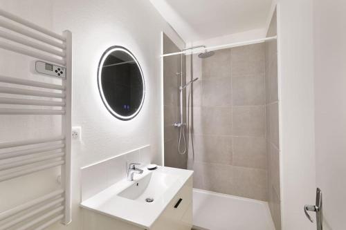 a white bathroom with a sink and a shower at Apparemment Cosy Paris CDG Stade Expo in Aulnay-sous-Bois