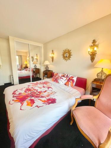 une chambre avec un grand lit et une chaise dans l'établissement Appartement cannes Croisette, à Cannes