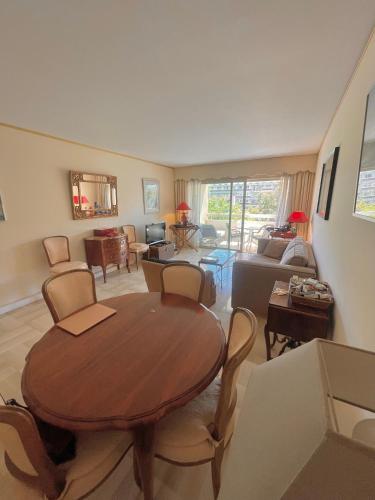 un salon avec une table et des chaises en bois dans l'établissement Appartement cannes Croisette, à Cannes