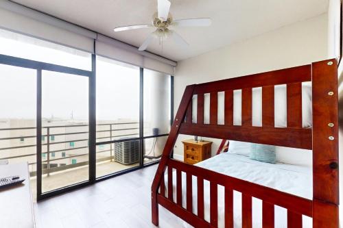 a bedroom with a bunk bed and a balcony at Sunchase IV in South Padre Island