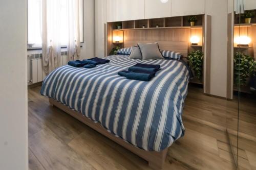 Una cama grande con almohadas azules encima. en Dimora Pietra Blu, en Pisa