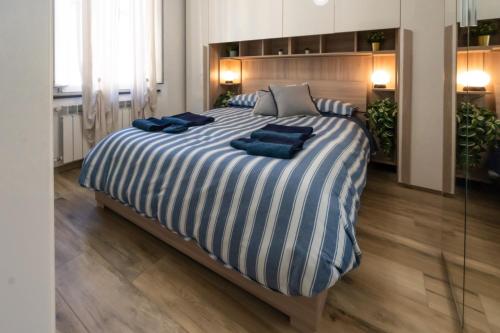 a large bed with blue pillows on top of it at Dimora Pietra Blu in Pisa