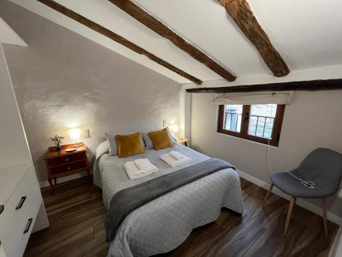 a bedroom with a bed and a desk and a chair at Casa rural abuela Gaspara in Alcalá del Júcar
