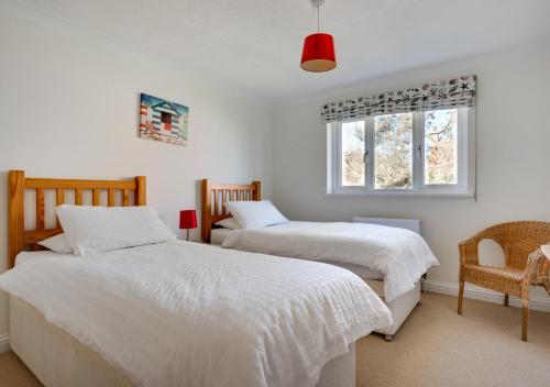 a bedroom with two beds and a window at Avocet House in Langham