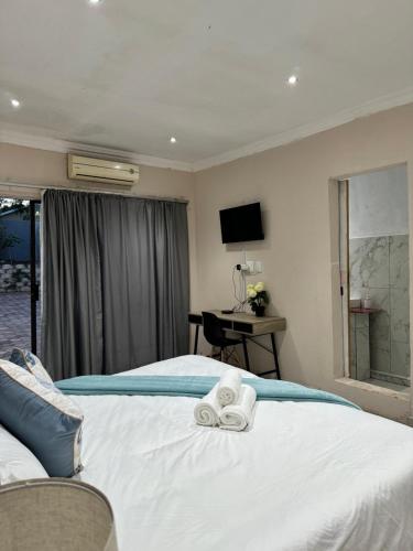 a bedroom with a bed with two towels on it at Entindini guest house in Empangeni