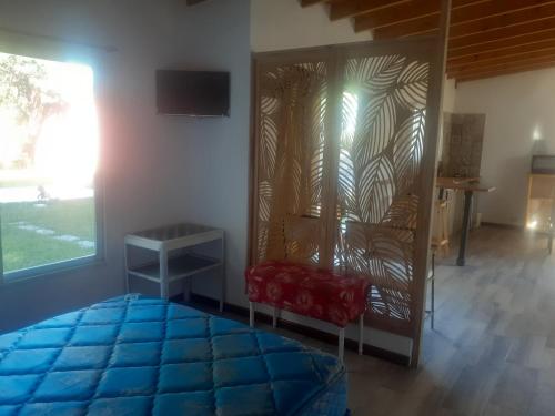 a living room with a blue rug and a chair and a window at Brisas de Atlantida in Santa Clara del Mar
