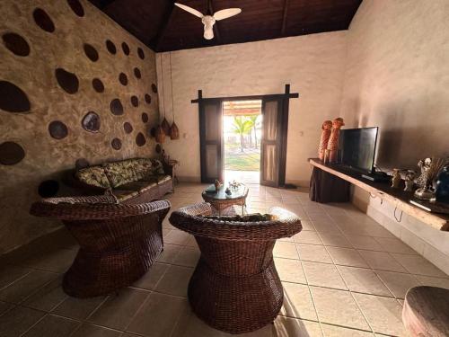 a living room with wicker chairs and a couch at Casa Pé na Areia Taipu de Fora 400m Piscinas Naturais in Barra Grande