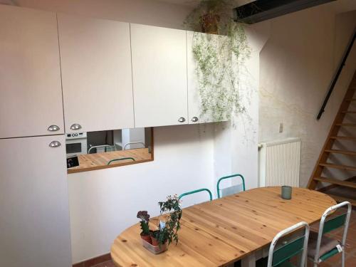 a kitchen with a wooden table and white cabinets at Cozy & Comfy House in Forest! in Brussels