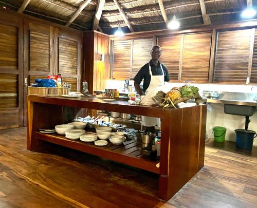 a man standing in a kitchen preparing food at Ebony Beach in Vilanculos