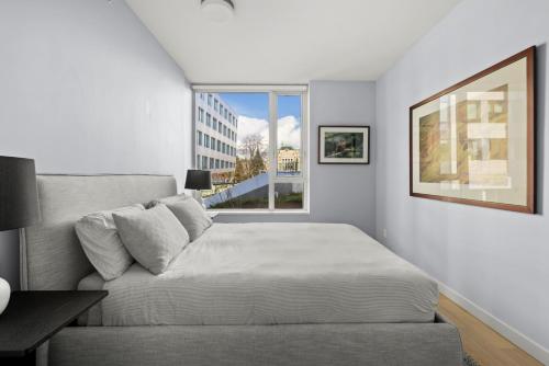 uma sala de estar com um sofá e uma janela em Pristine & Modern Parliament View Condo, James Bay, Gym, Parking. em Victoria