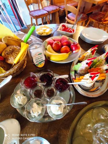 a table topped with plates of food and fruit at Marktstübchen an der schönen Loreley in Bornich