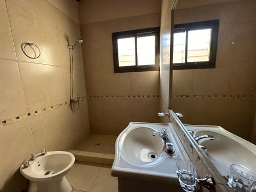 y baño con lavabo, bañera y aseo. en Casa tranquila y cómoda, muy cerca del centro en Tunuyán