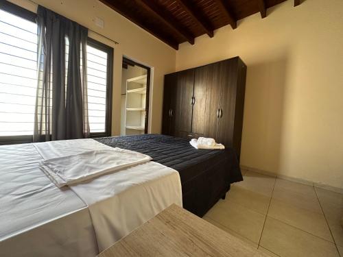 1 dormitorio con 1 cama y armario de madera en Casa tranquila y cómoda, muy cerca del centro en Tunuyán