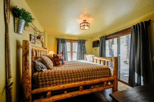 um quarto com uma cama de madeira e uma janela em Little Badger Lodge em Lead