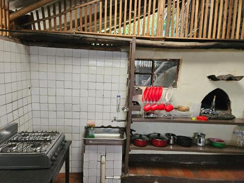 una cocina con ollas rojas y sartenes en un estante en Casa Guicán, en Güicán
