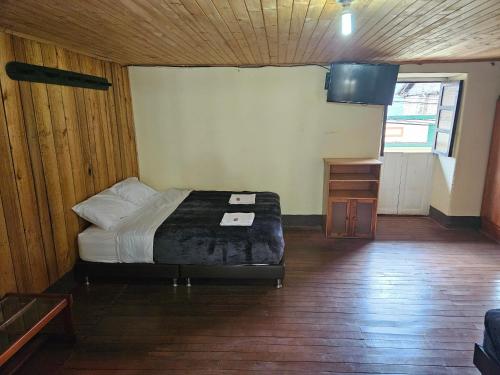 a bedroom with a bed and a wooden floor at Casa Guicán in Güicán
