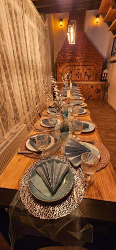 a long table with plates and napkins on it at Vikendica OM relax in Prijedor