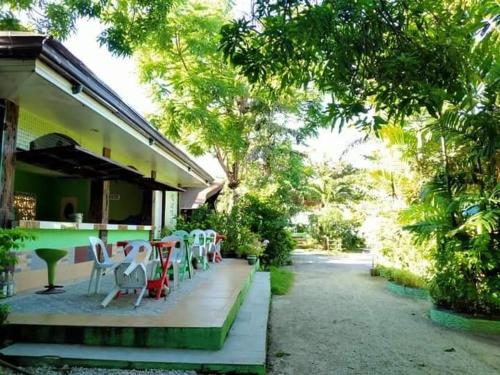 a group of chairs sitting on the porch of a house at Palm Garden Resort in Carles