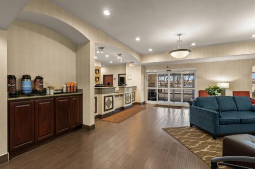 a living room with a blue couch and a kitchen at Comfort Inn Ogden near Event Center in Ogden