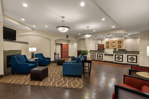 a hotel lobby with blue chairs and a kitchen at Comfort Inn Ogden near Event Center in Ogden