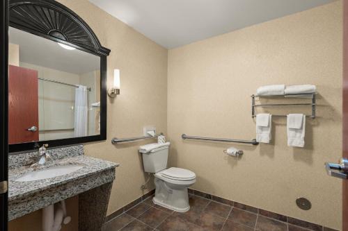a bathroom with a toilet and a sink and a mirror at Comfort Inn Ogden near Event Center in Ogden