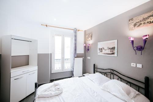 a bedroom with a white bed and a window at Hotel De La Poste in Paris