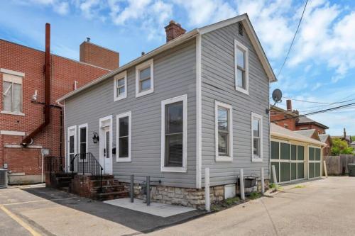 a gray house with white trim on a street at Housepitality - The Marienplatz - Free Parking in Columbus