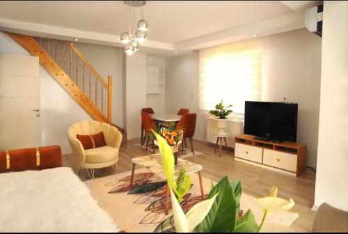 - un salon avec une télévision et une table avec des chaises dans l'établissement ISTANBUL APARTMENT Stylish&Lively, à Istanbul