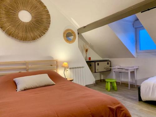 um quarto com uma grande cama laranja num sótão em Au cœur du centre historique ! em Beauvais