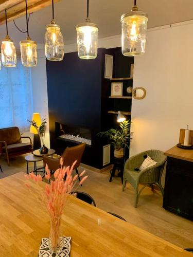 - un salon avec une table, des chaises et des lumières dans l'établissement Maison Centre Ville Centre Historique, à Beauvais
