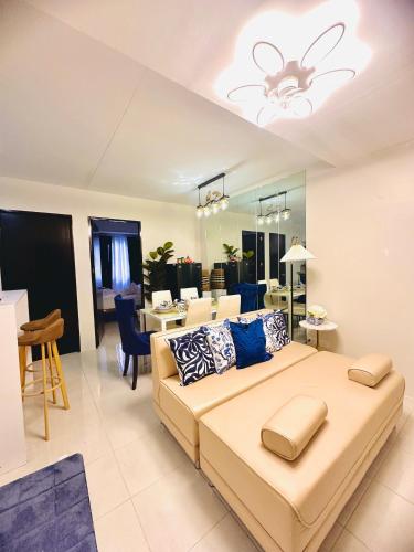 a bedroom with a large bed and a living room at CasadeIsabel: Elegant 2BR n Cebu/Washing/Netflix in Cebu City