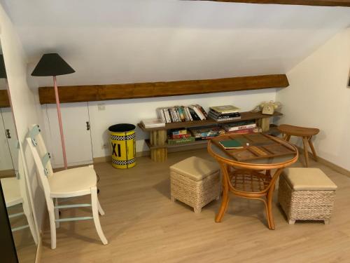 - un salon avec une table, des chaises et un bureau dans l'établissement LES BAINS, à Barneville-Carteret